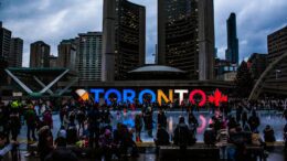 Vibrant evening at Toronto City Hall with festive crowd enjoying the cityscape.