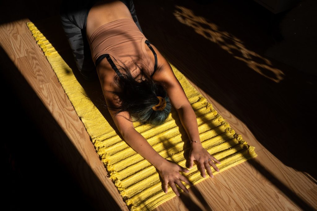 woman in black tank top lying on yellow hammock