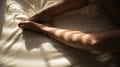 human feet on white bedspread close-up photography