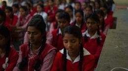 girls sitting in a classroom with eyes closed
