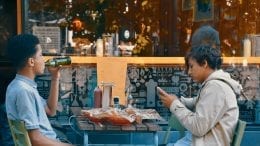 two men sitting on chair front of table