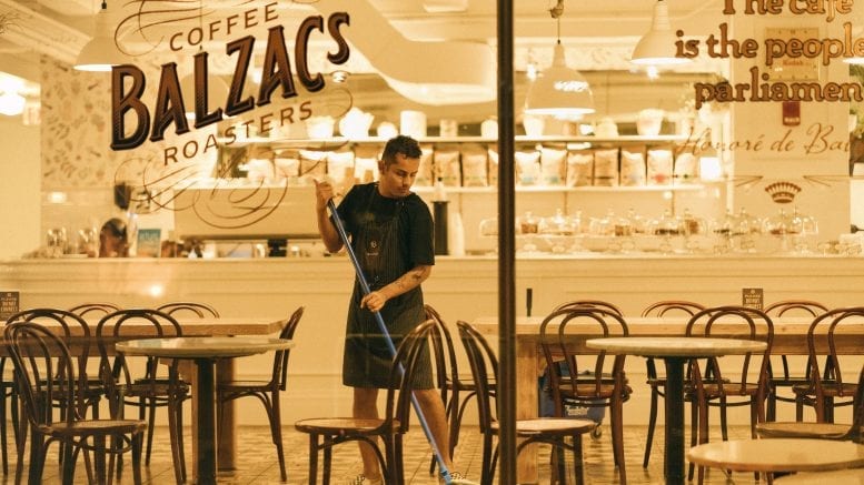 sanitation man mopping floor of Coffee Balzac's roaster