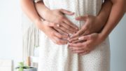 person touching person's belly symptoms of pregnancy