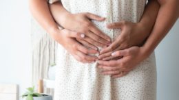 person touching person's belly symptoms of pregnancy